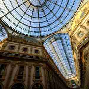 Low angle shot of glass ceiling with white and golden walls with pictures